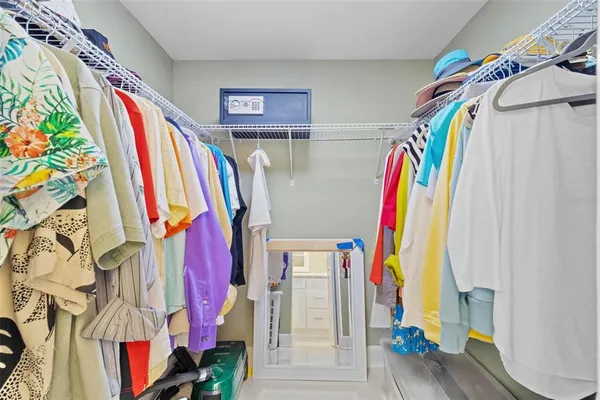 a bedroom with a bed a chandelier and a dresser