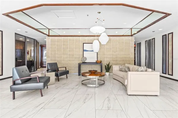 a living room with furniture and a floor to ceiling window
