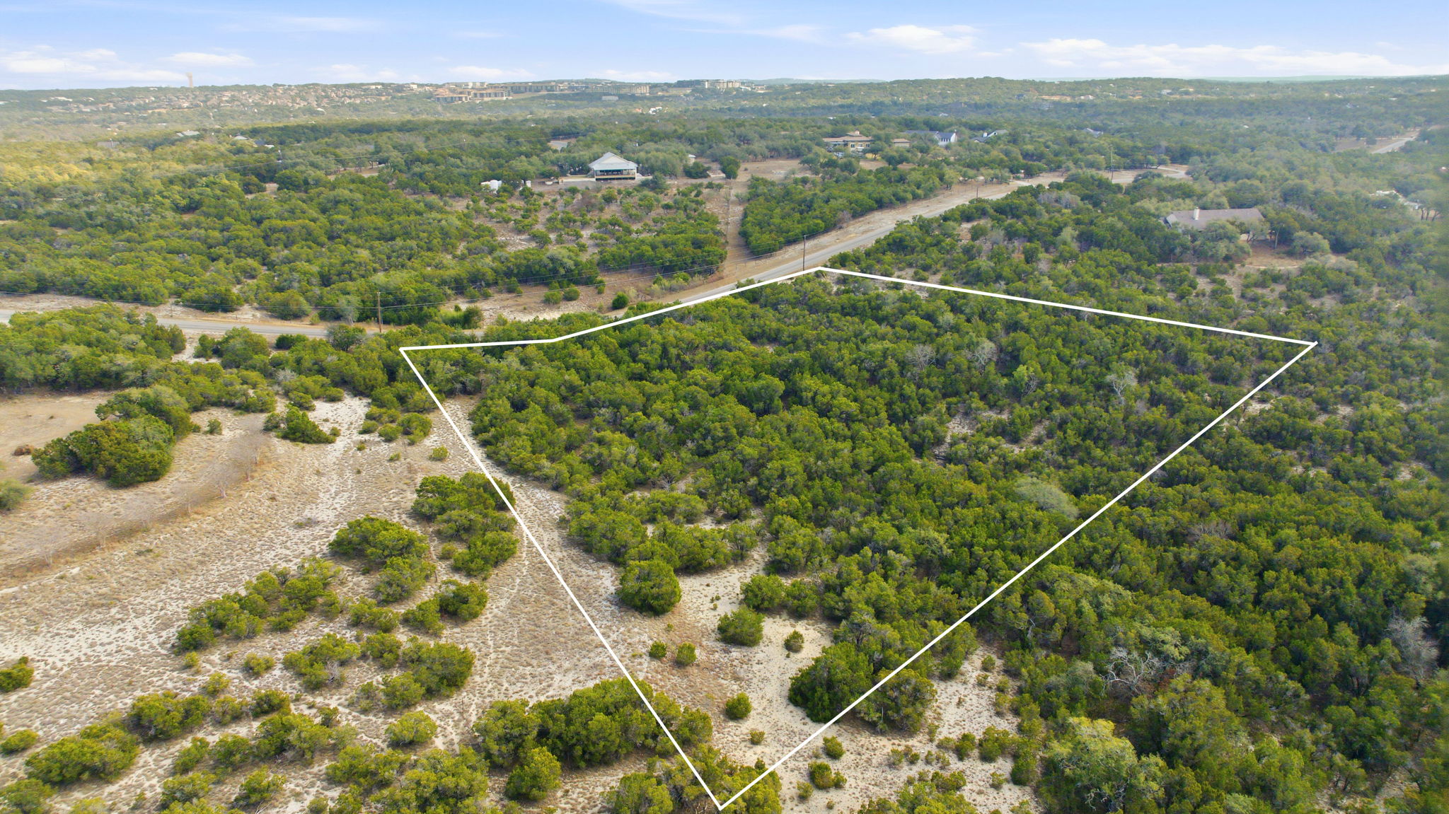 Aerial view of property and surrounding area featuring a heavily wooded area and property boundaries highlighted