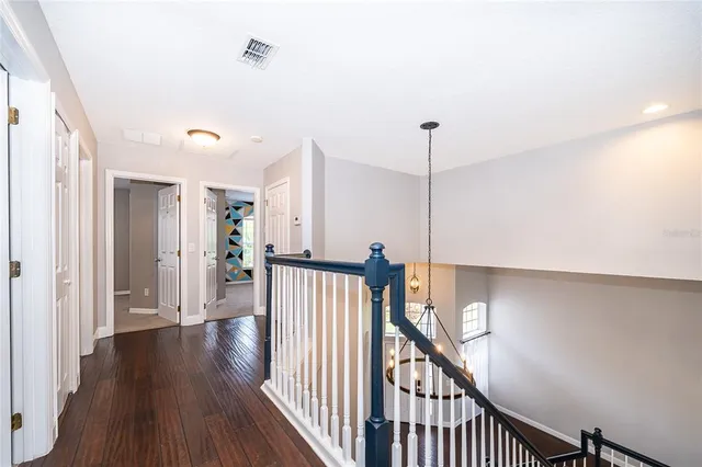 a view of a hallway with wooden floor and stairs
