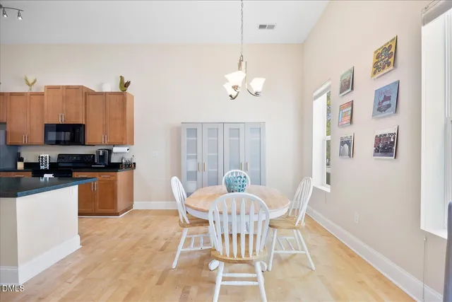 a view of a dining room with furniture a chandelier and wooden floor