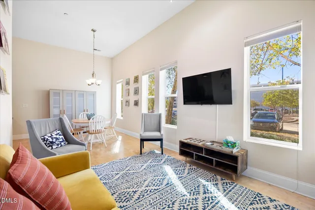 a living room with furniture a flat screen tv and a window