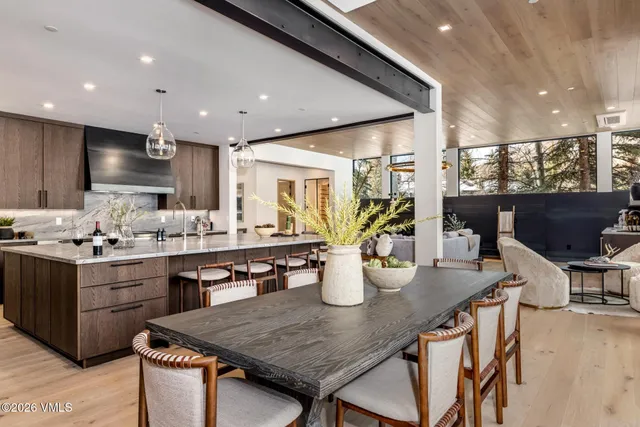 a kitchen with stainless steel appliances granite countertop table chairs sink and stove