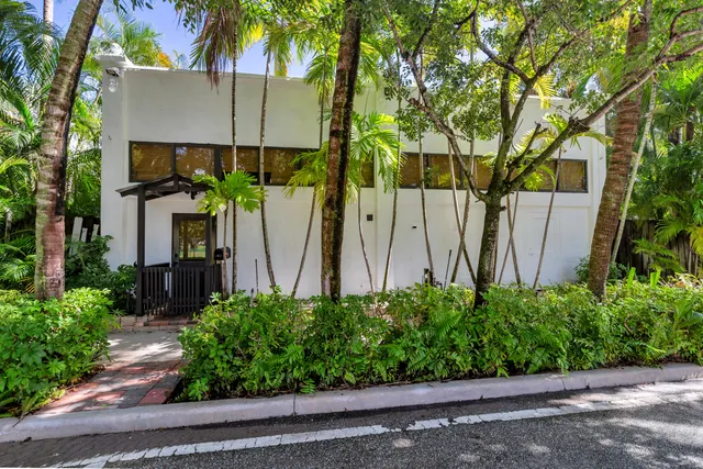 a front view of a house with a yard and potted plants