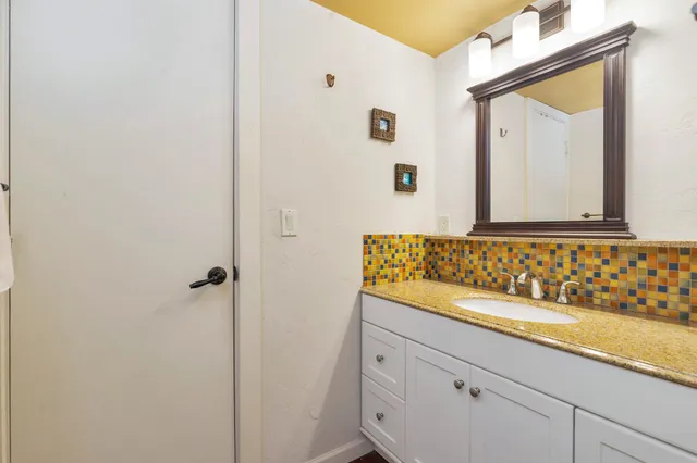 a bedroom with a bed and a lamp on dresser