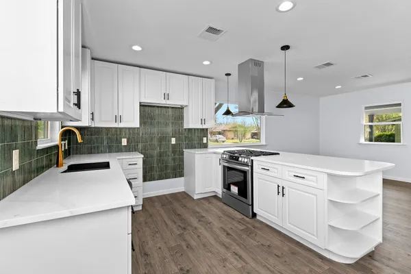 a kitchen with a stove a sink a refrigerator and a cabinets