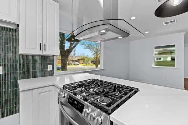 a kitchen with stove and cabinets