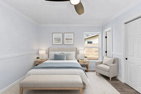 a bedroom with furniture and a large window