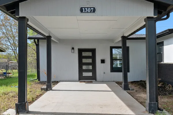 a hallway with a door and a rug