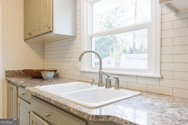 a bathroom with a granite countertop sink and a window