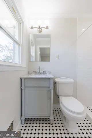 a bathroom with a sink toilet and window