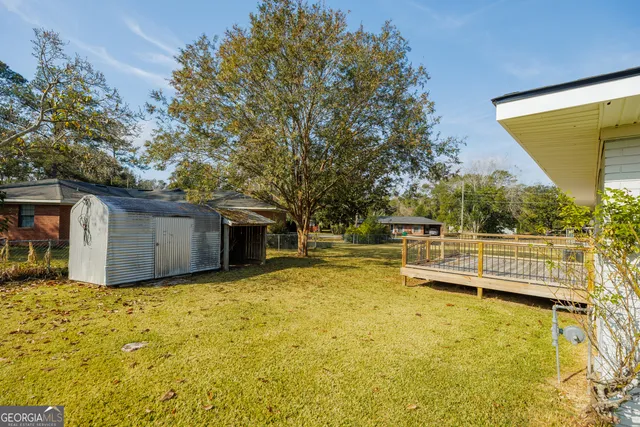 a view of a small house with wooden fence