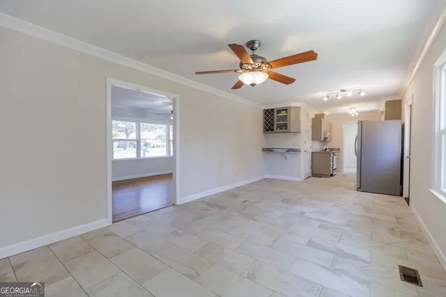 an empty room with windows and a ceiling fan