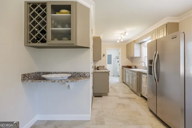 a kitchen with stainless steel appliances granite countertop a refrigerator a stove and a sink