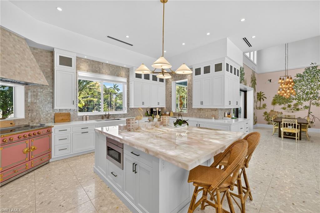 111 Caribbean Road Naples, FL 34108 - Photo 16 of 50 a large white kitchen with a large island oven a sink a stove and a large window