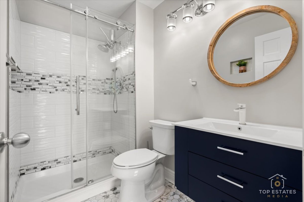 1227 South Old Wilke Road, Unit 201 Rolling Meadows, IL 60005 - Photo 25 of 40 a bathroom with a toilet a sink a mirror and shower