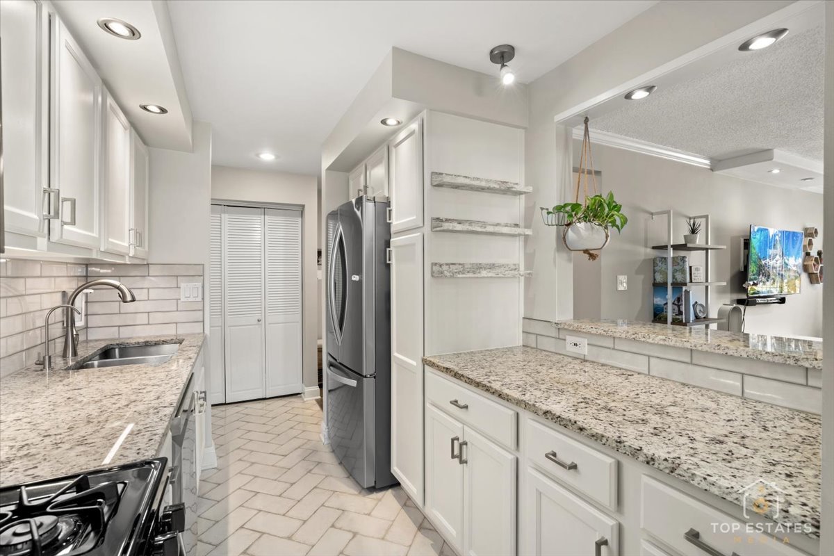 1227 South Old Wilke Road, Unit 201 Rolling Meadows, IL 60005 - Photo 3 of 40 a kitchen with stainless steel appliances granite countertop a refrigerator and a sink