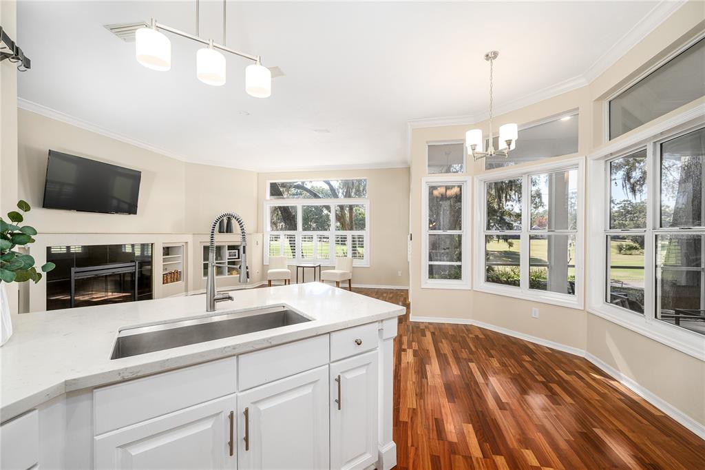 4417 Southwest 91st Drive Gainesville, FL 32608 - Photo 16 of 54 a view of a kitchen with a sink dishwasher microwave oven and a dining table with wooden floor
