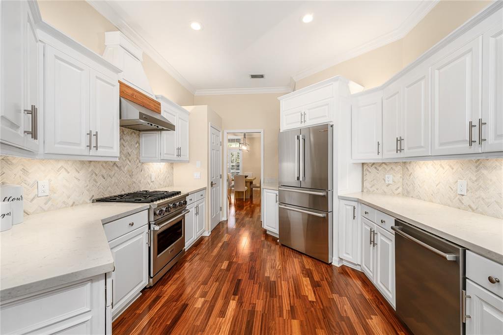 4417 Southwest 91st Drive Gainesville, FL 32608 - Photo 18 of 54 a kitchen with wooden floors and stainless steel appliances
