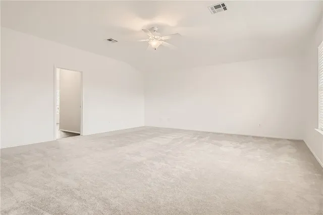 an empty room with an entryway and a fan