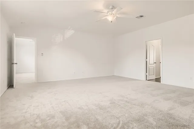 an empty room with an entryway and fan