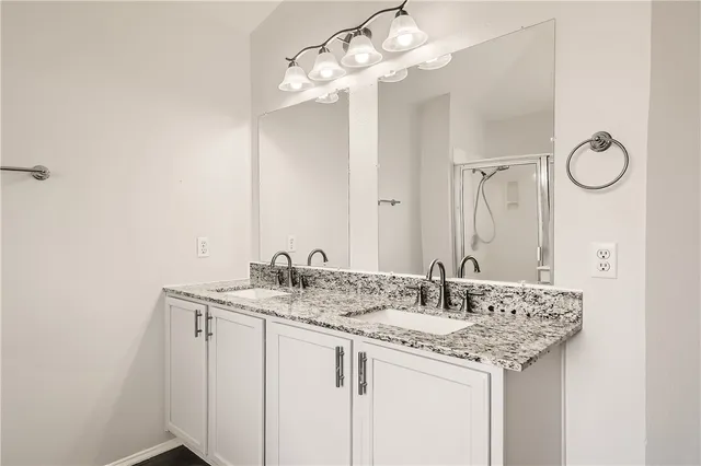 a bathroom with a granite countertop sink a mirror and a vanity