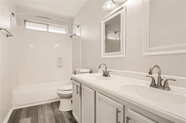 a bathroom with a granite countertop sink a toilet and a bathtub