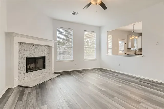 an empty room with windows and fireplace