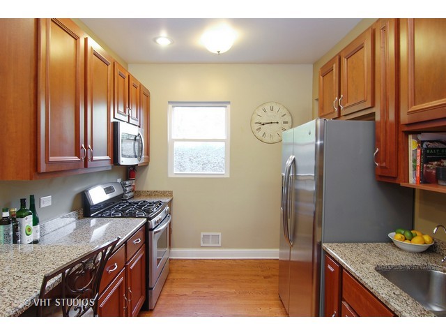 238 Lionel Road Riverside, IL 60546 - Photo 8 of 24 a kitchen with stainless steel appliances granite countertop a sink a stove and a refrigerator with wooden floor
