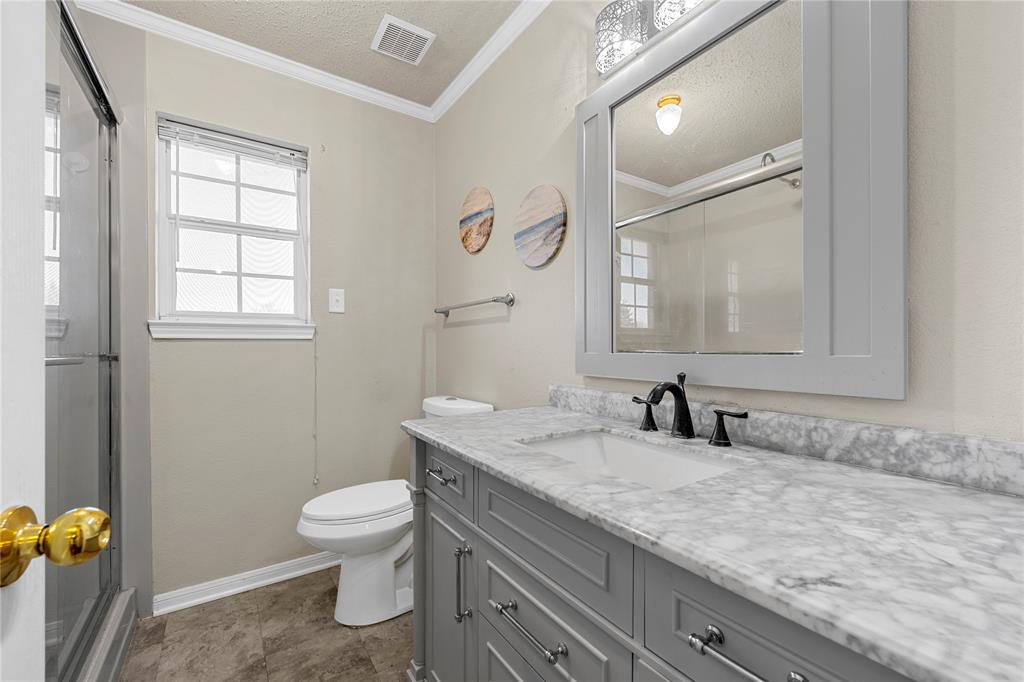494 Westgate I Road Eddy, TX 76524 - Photo 18 of 34 Full bathroom featuring vanity, a textured ceiling, a stall shower, crown molding, and healthy amount of natural light