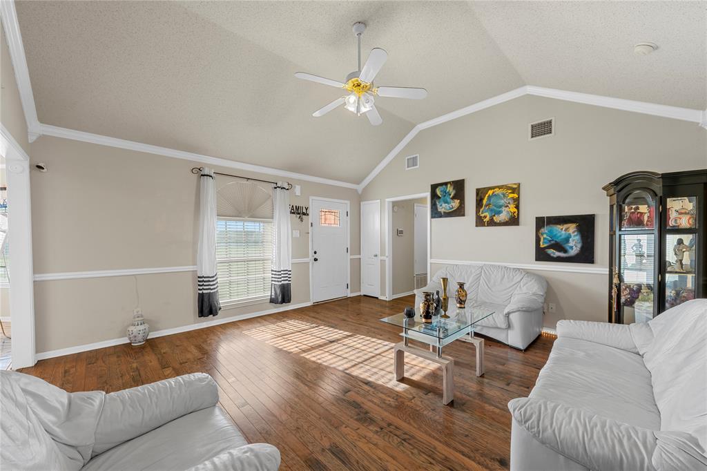 494 Westgate I Road Eddy, TX 76524 - Photo 8 of 34 Living room featuring dark wood-type flooring, a ceiling fan, a textured ceiling, and ornamental molding
