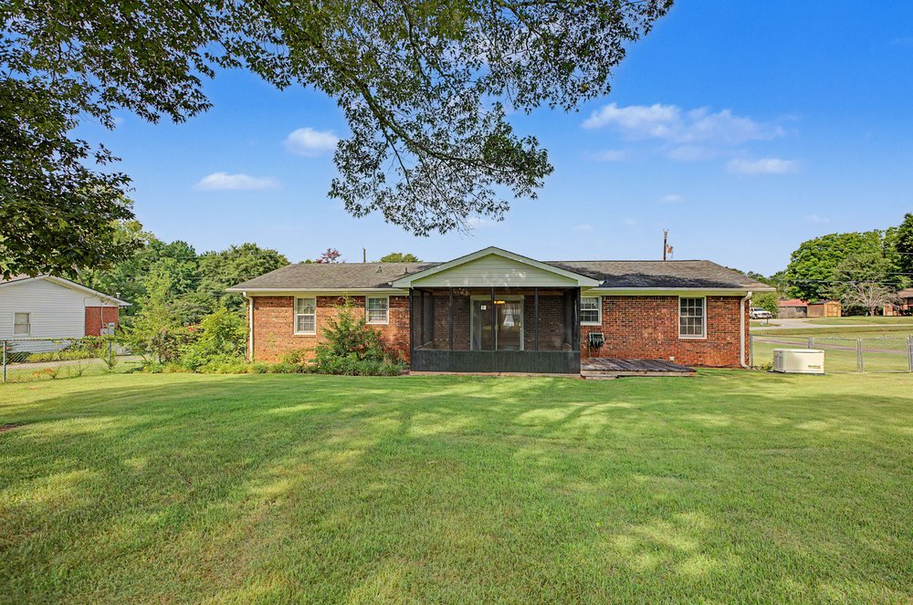 115 Brunson Drive Pickens, SC 29671 - Photo 25 of 29 A spacious grassy yard provides ample outdoor living space behind a classic brick home.