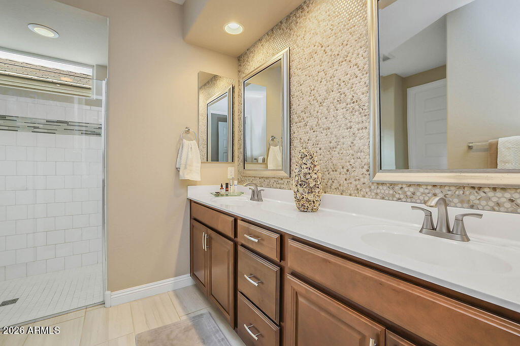 2523 East Nancy Lane Phoenix, AZ 85042 - Photo 19 of 48 a bathroom with a double vanity sink a mirror and a shower