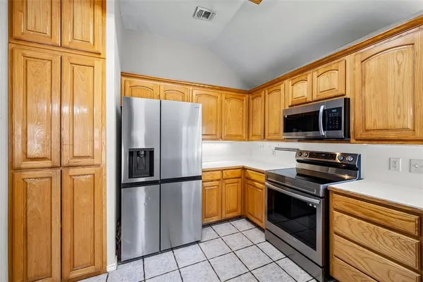 a kitchen with stainless steel appliances granite countertop a refrigerator stove and microwave