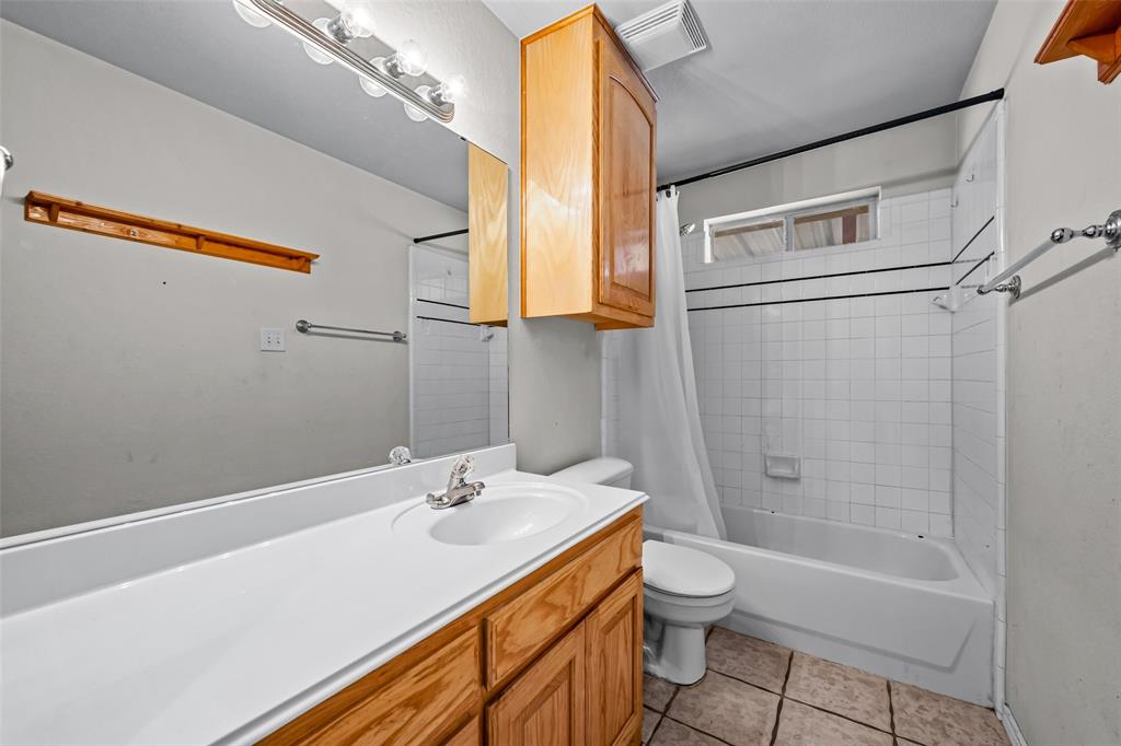 7698 Farm To Market 920 Poolville, TX 76487 - Photo 16 of 37 a bathroom with a granite countertop sink a toilet and shower