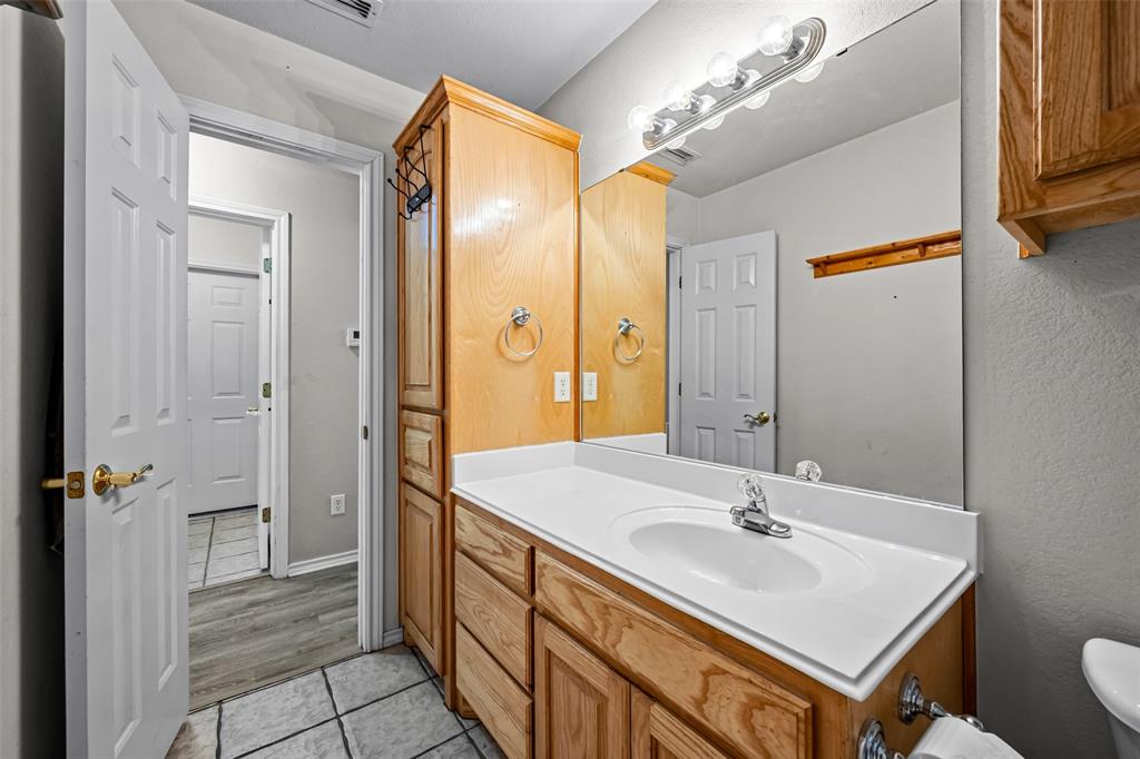 7698 Farm To Market 920 Poolville, TX 76487 - Photo 17 of 37 a bathroom with a sink double vanity and a mirror