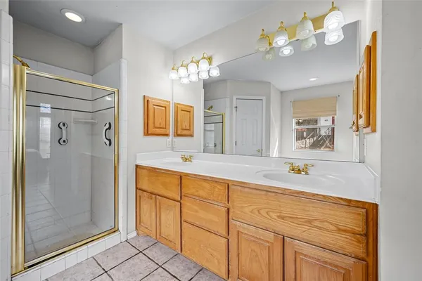 a spacious bathroom with a granite countertop sink a large mirror and a shower