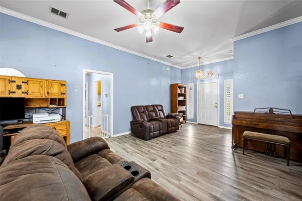 a living room with furniture and a flat screen tv with wooden floor