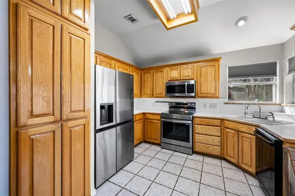 a kitchen with stainless steel appliances granite countertop a refrigerator and a stove top oven