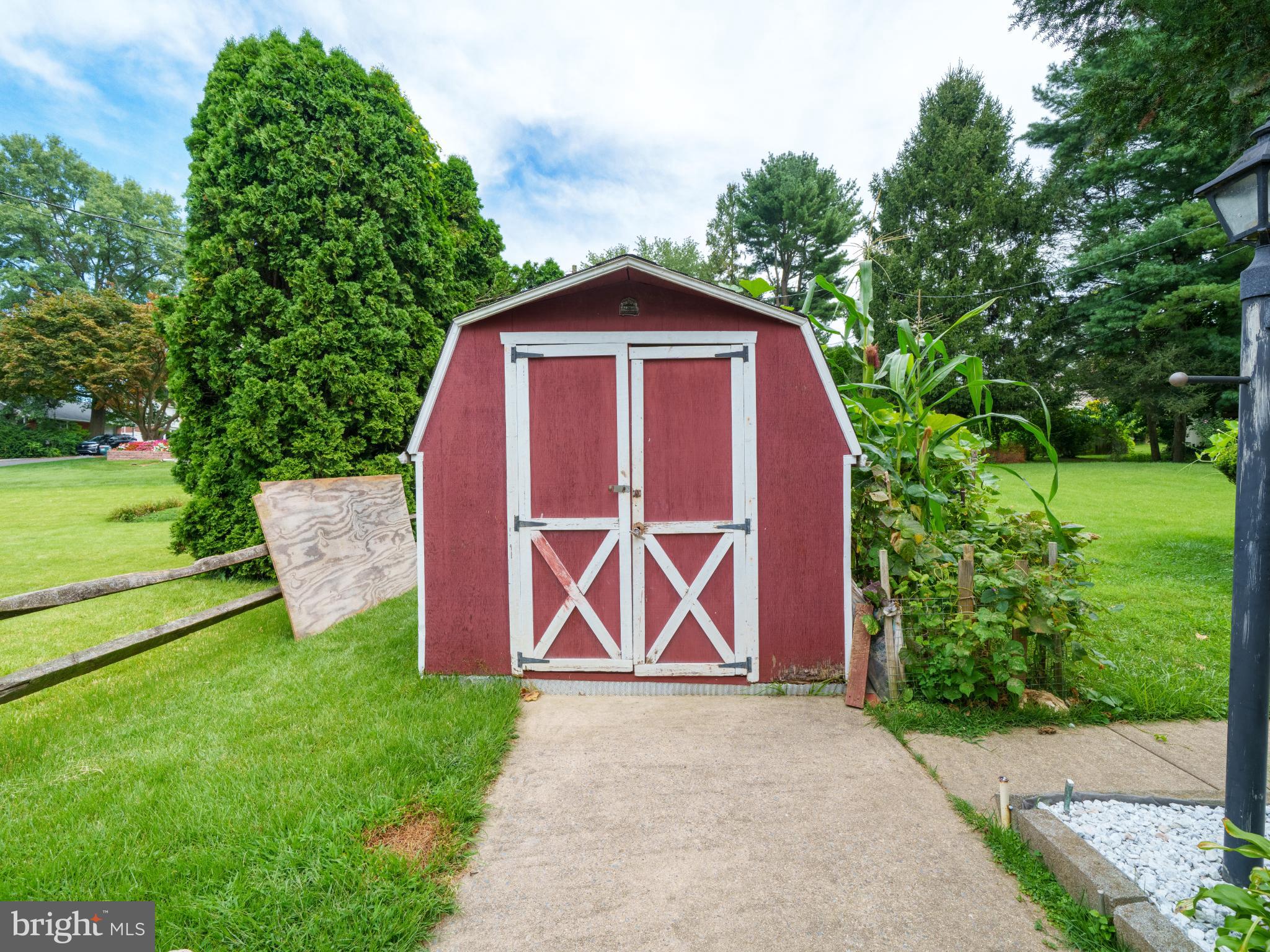 105 School House Road Lancaster, PA 17603 - Photo 27 of 33 Charming red shed nestled in lush greenery.