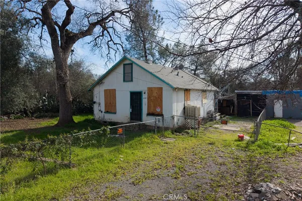 a view of a house with backyard and trees
