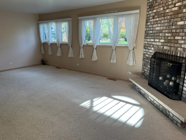915 Harmoni Lane New Lenox, IL 60451 - Photo 27 of 38 a view of an empty room with wooden floor and a fireplace