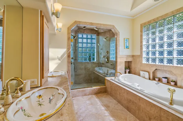 a bathroom with a tub a sink and a large mirror