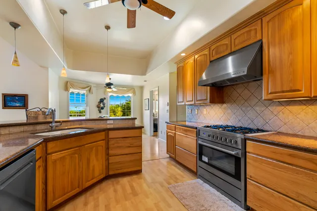 a kitchen with stainless steel appliances wooden cabinets and a stove top oven