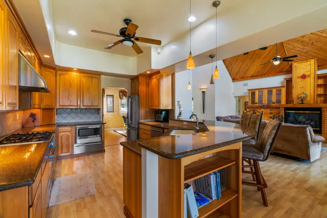a kitchen with stainless steel appliances granite countertop a stove a sink and a refrigerator