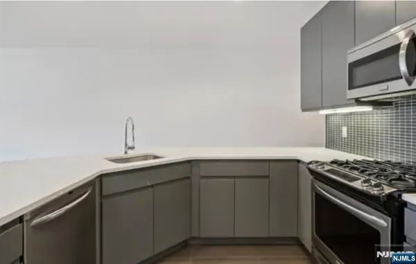 a kitchen with cabinets stainless steel appliances and a sink
