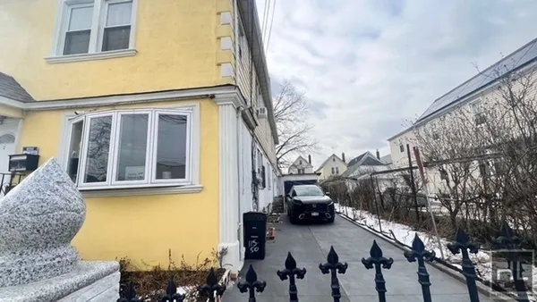 a view of a city street with house and car parked