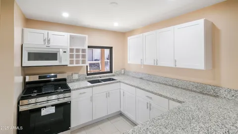 a kitchen with white cabinets stainless steel appliances and sink