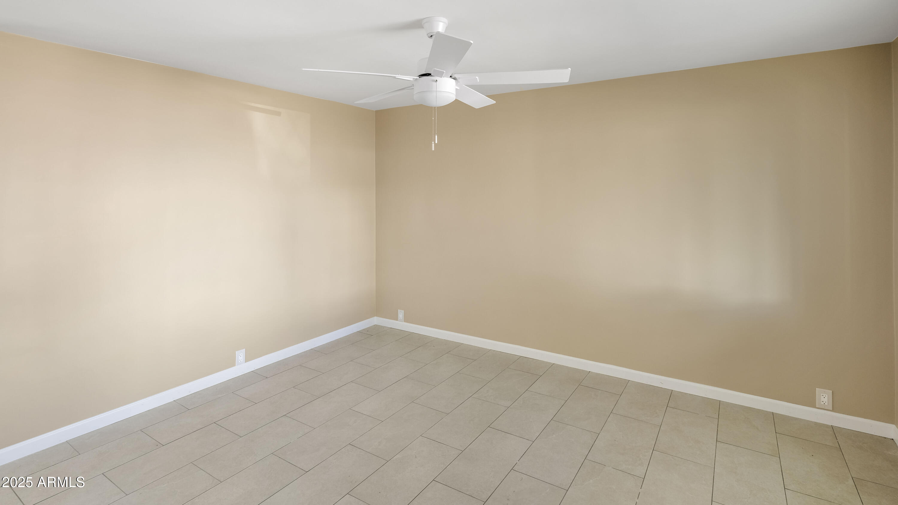 2333 West Coolidge Street Phoenix, AZ 85015 - Photo 4 of 9 an empty room with a ceiling fan and carpet