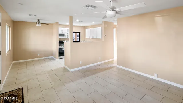 an empty room with kitchen view and a window